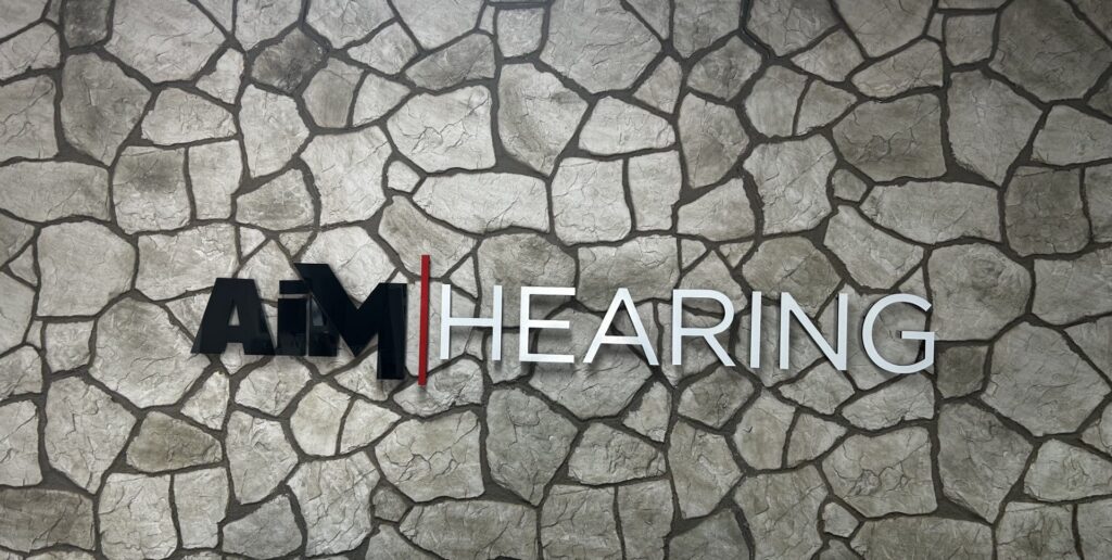 AIM Hearing signage on the stone feature wall at the Avoca clinic in Bundaberg
